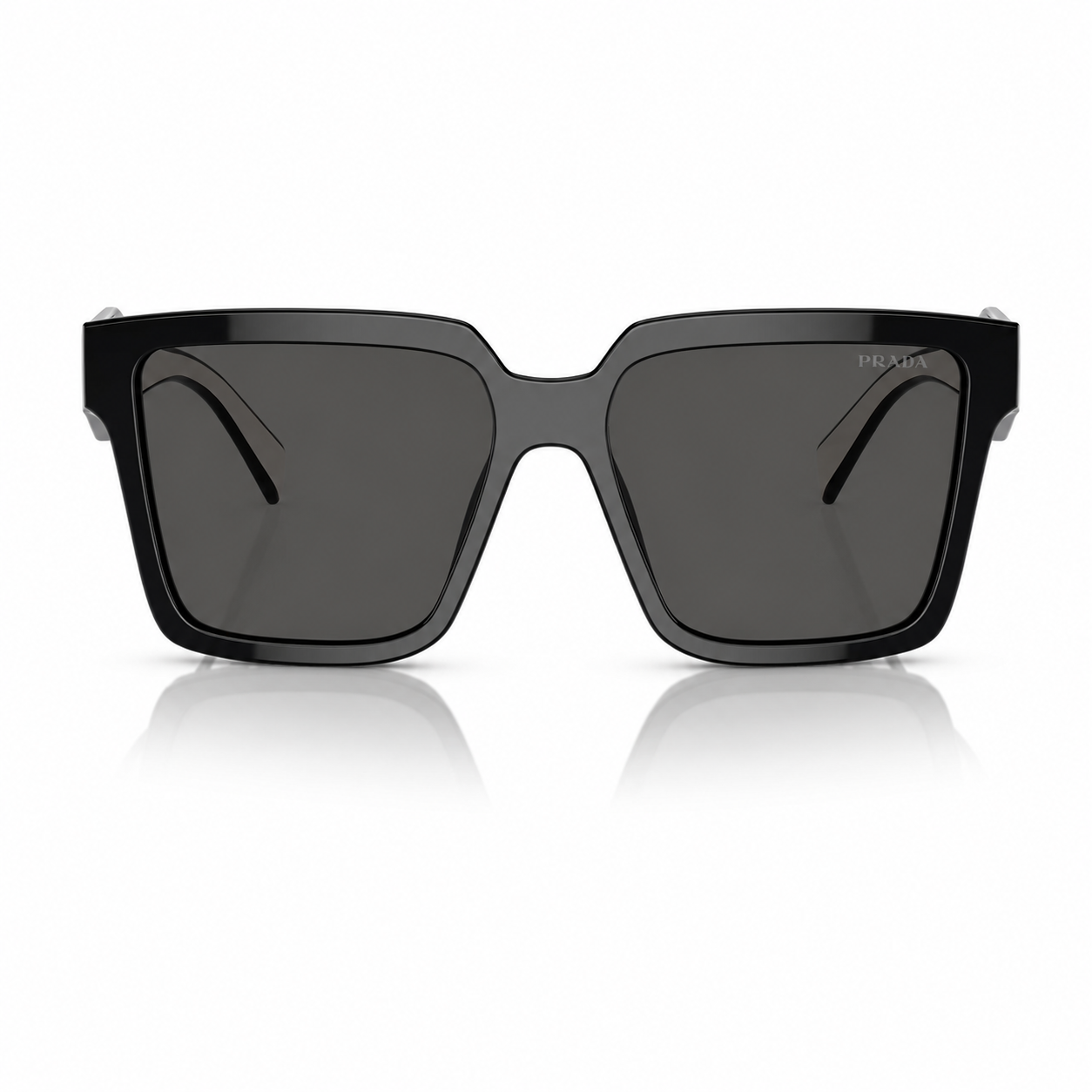 Lentes de sol Prada negros vista frontal Lentes de sol Prada negros en vista frontal, con montura gruesa, cristales oscuros y diseño cuadrado sobre fondo blanco.